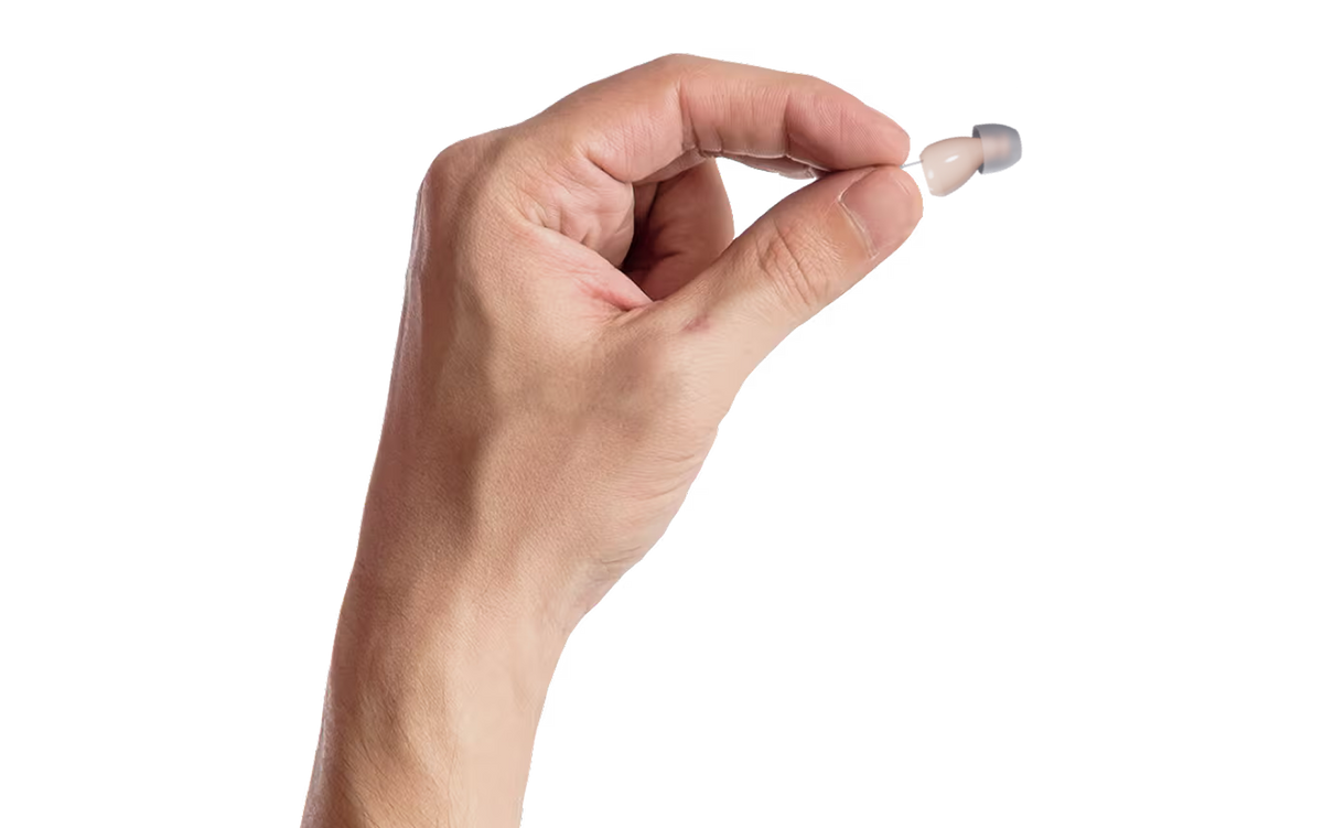 Hand holding a small hearing aid on a transparent  background