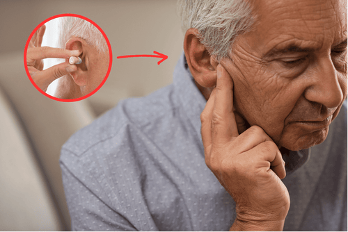 Senior man rubbing his ears, indicating he may need hearings aids like the Audien Atom 2 Series