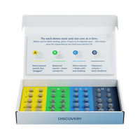 A boxed audio equipment kit labeled DISCOVERY, shown open on a white background. The kit contains four rows of dome-shaped earplugs in yellow, green, blue, and navy, with a printed insert explaining how to organize the items by style and size.