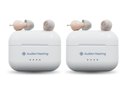Two white hearing aid cases with ear-shaped covers on a white background, featuring the Audien Hearing logo.
